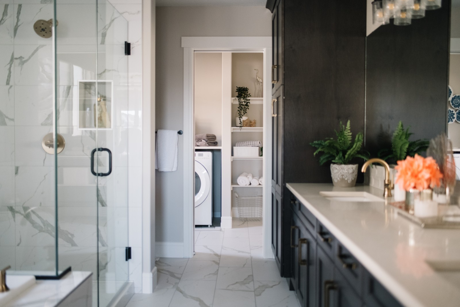 The master ensuite of the Julian showhome that features dark rich stained cabinets, a fully tiled glass enclosed shower and leads directly to the laundry room at the back of the ensuite