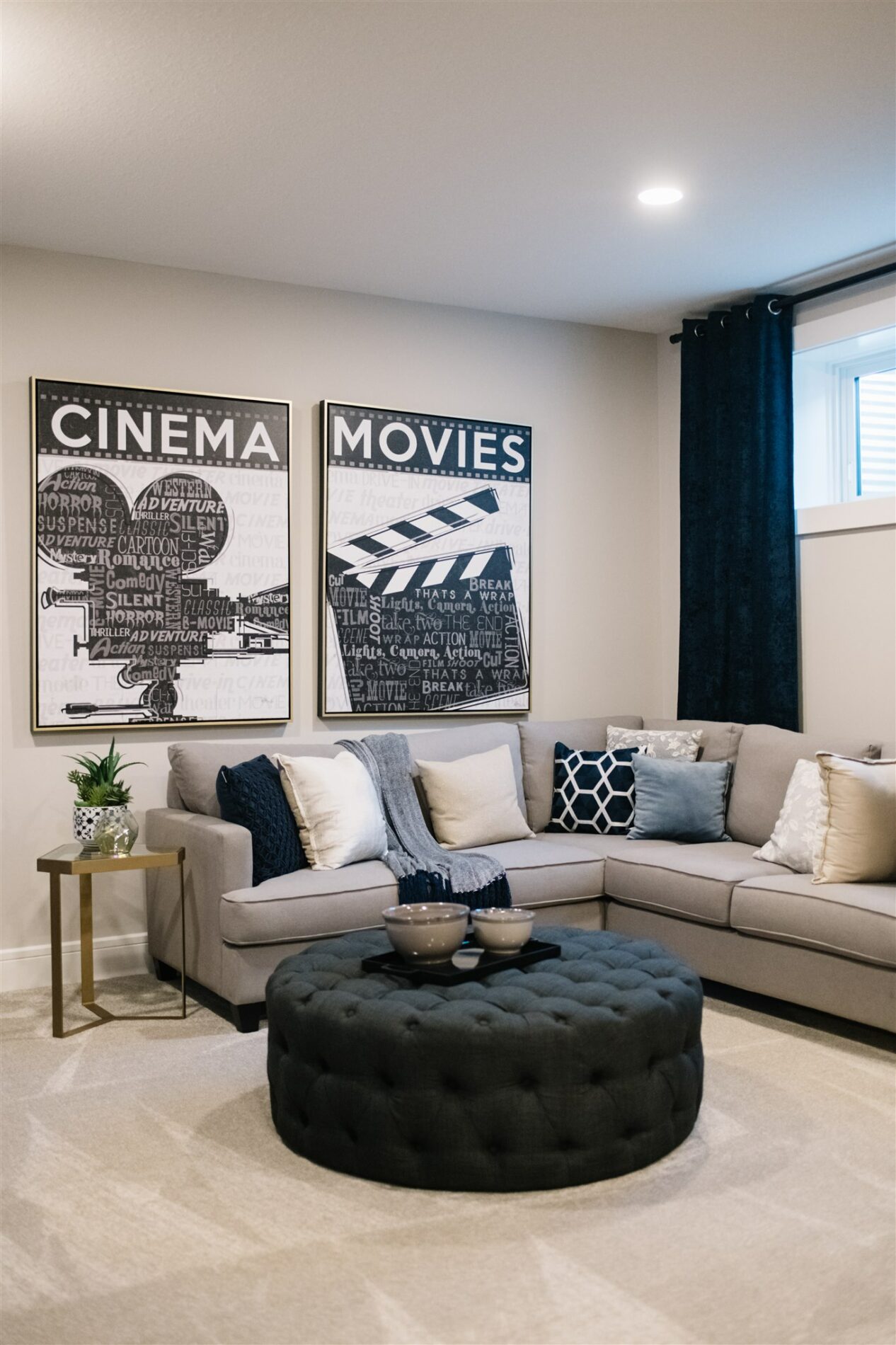 Cozy family room with inviting sectional couch with blue accent pillows and framed movie art hanging on the wall