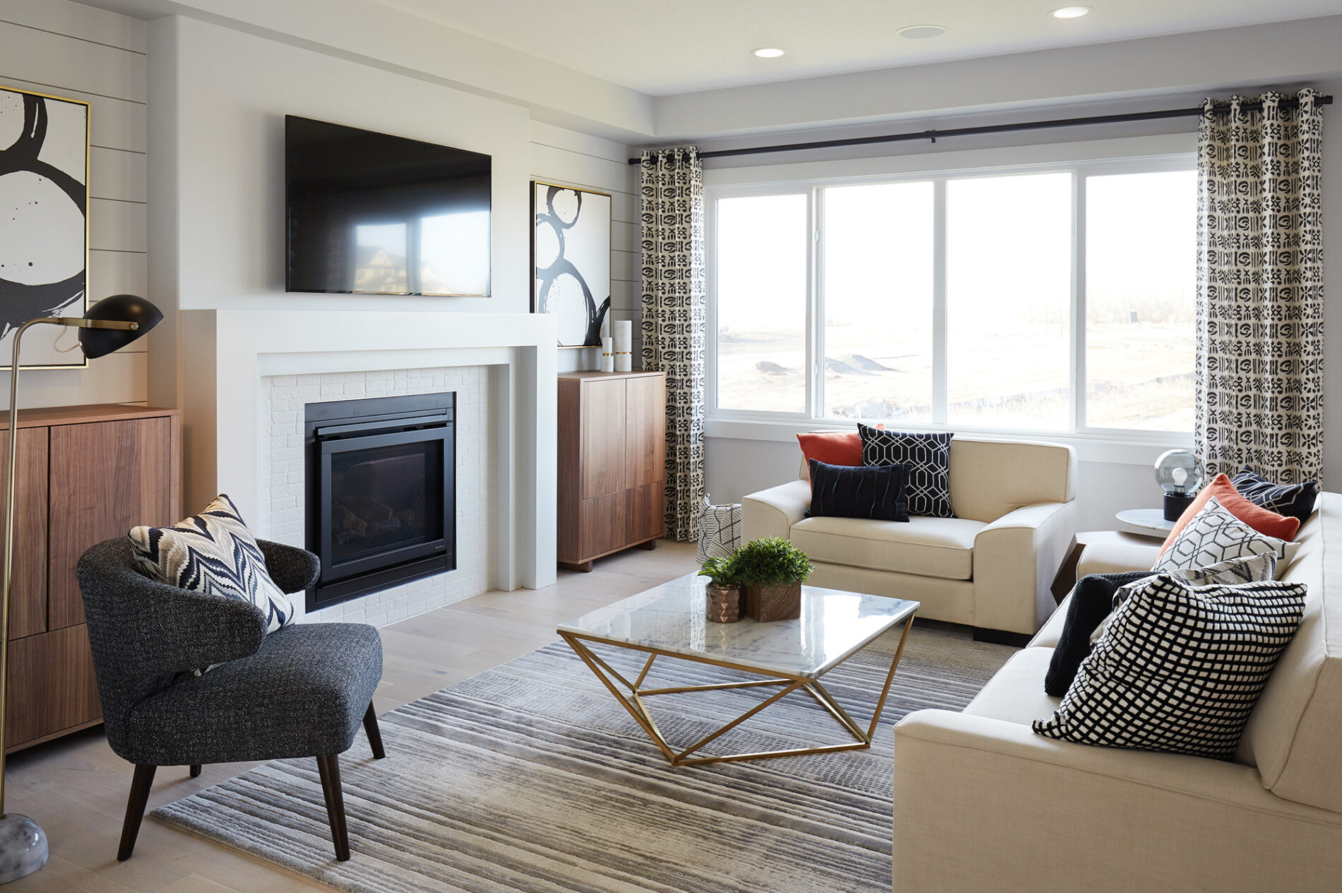 Bright great room centered around the contemporary fireplace with white brick tile and simple tiered surround, with shiplap detail on walls flanking the fireplace