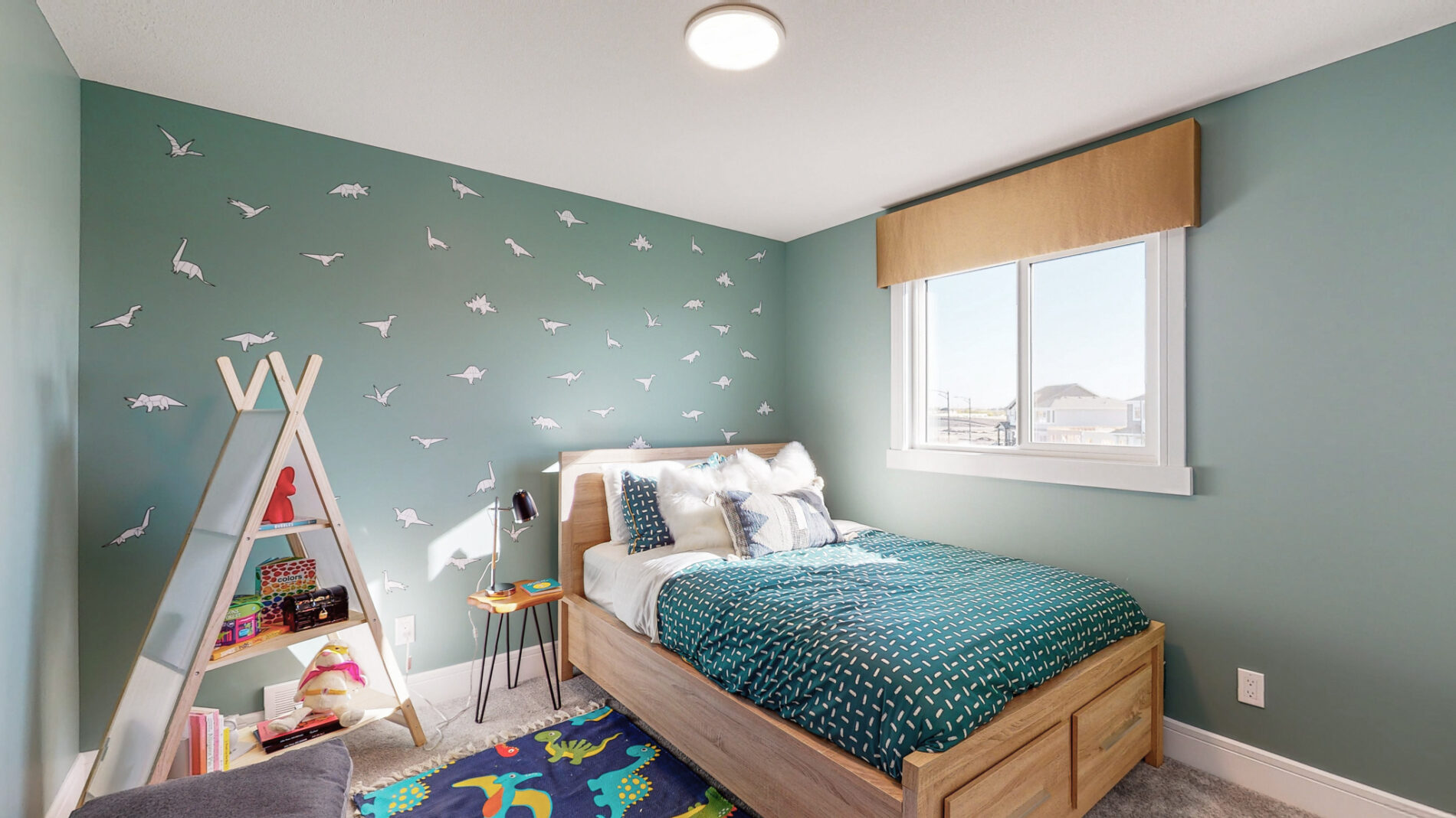 Natural light floods a green secondary bedroom with wood bed frame, complementing green bedding and tent shaped shelf in the corner