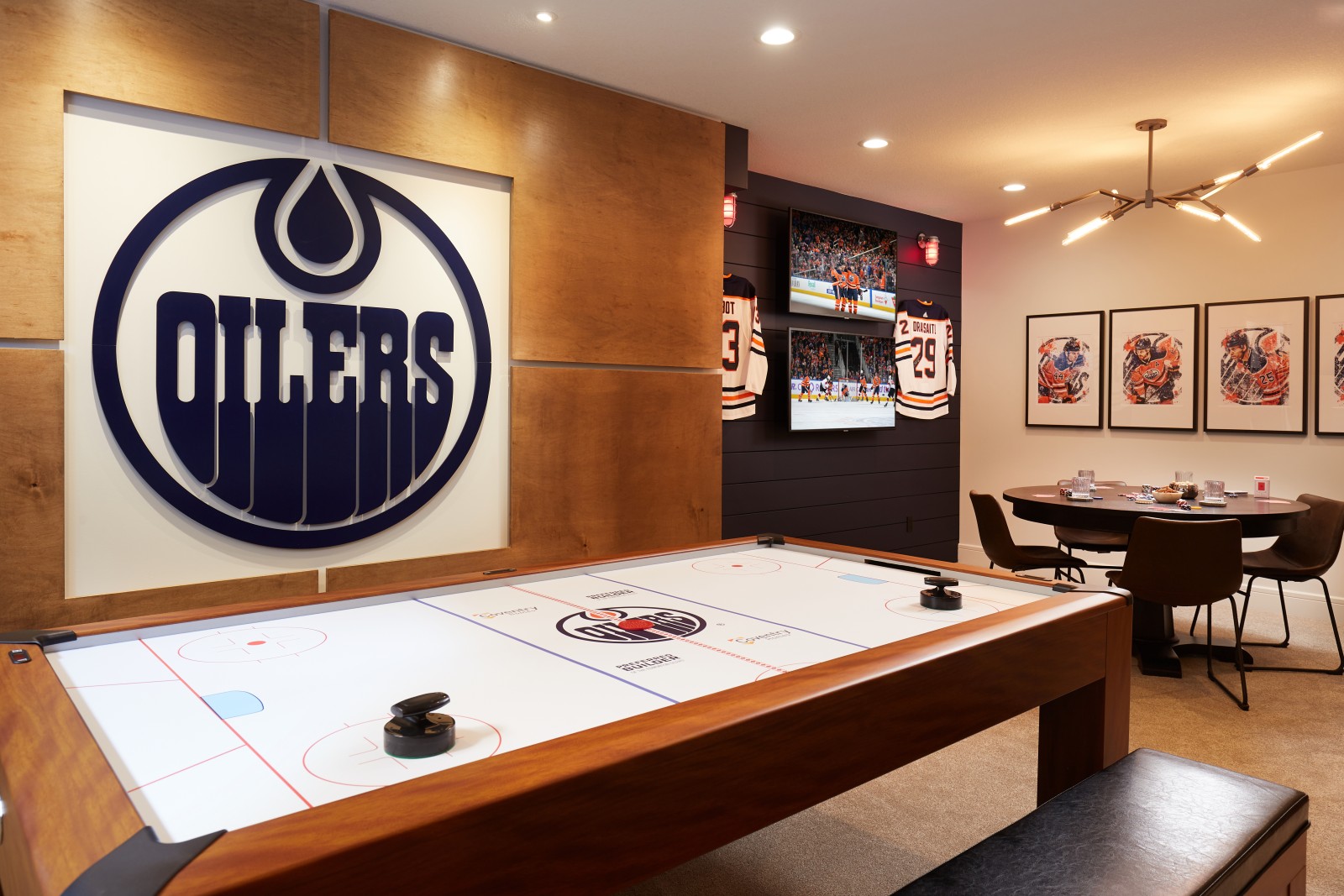 Archer Showhome Fan Cave photo with large, blue, Oilers logo on feature wall with warm wood panels around it