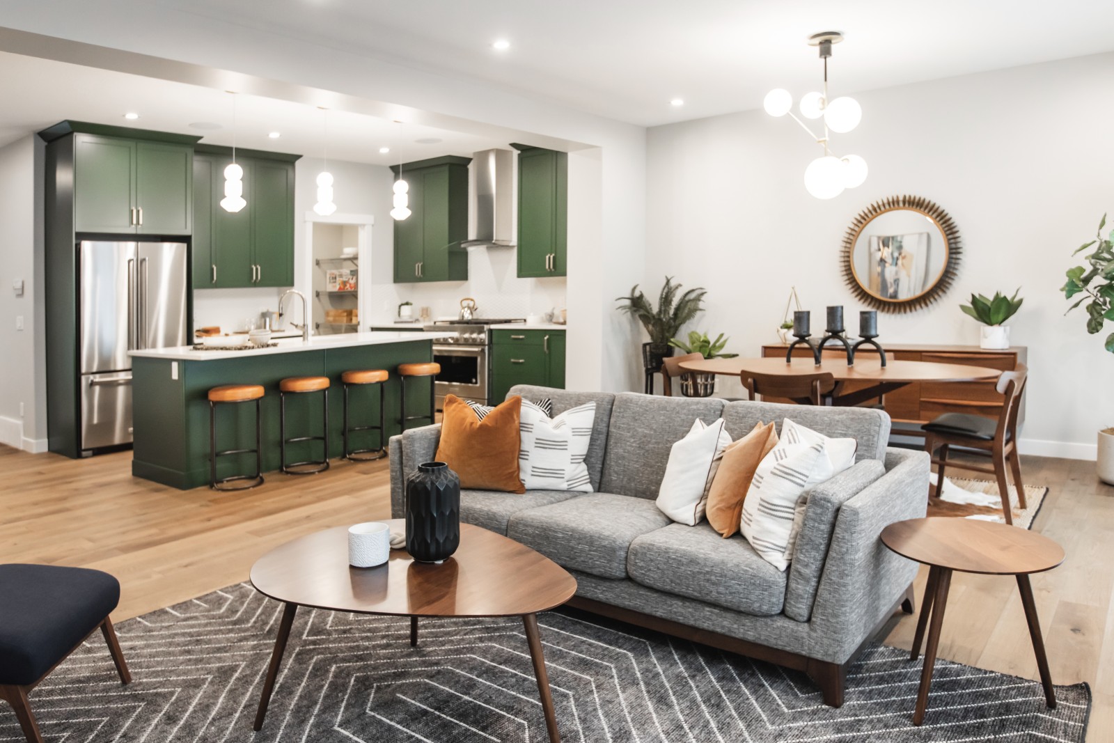 A mid-century inspired kitchen and dining nook in the Bianca showhome featuring bold green cabinets and mid-century dining furniture and accessories