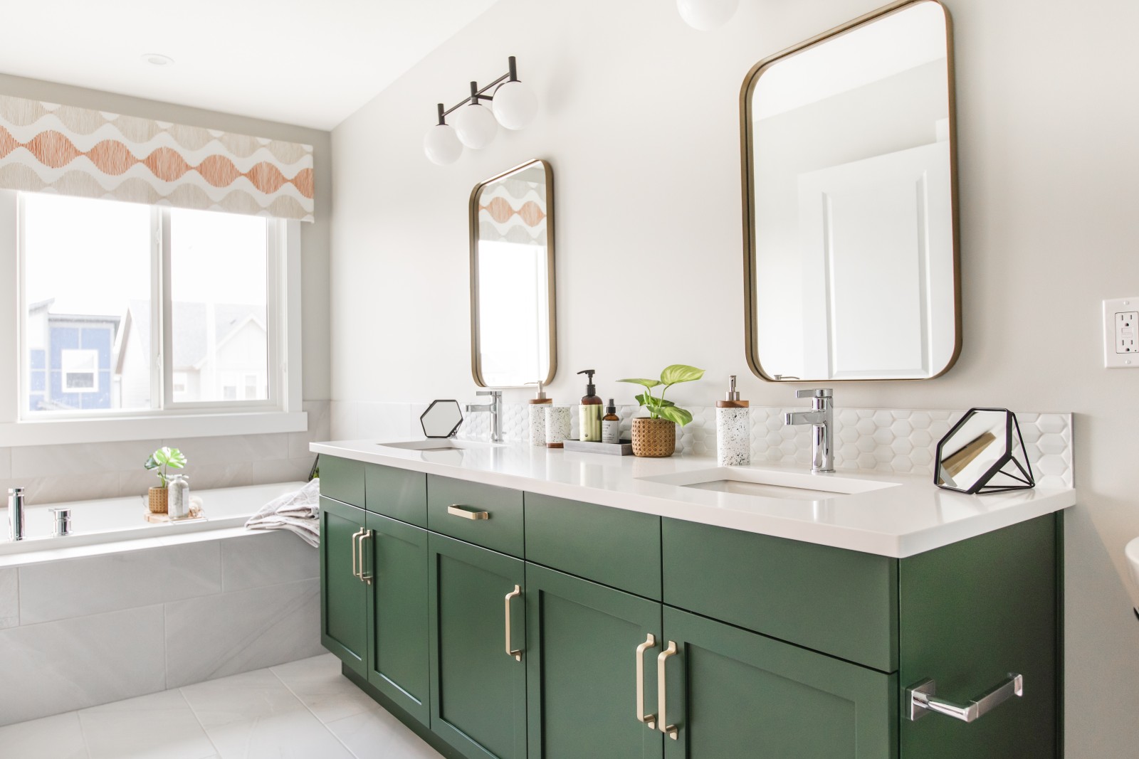Rich green vanity of Bianca showhome accented with gold handles and gold mirrors