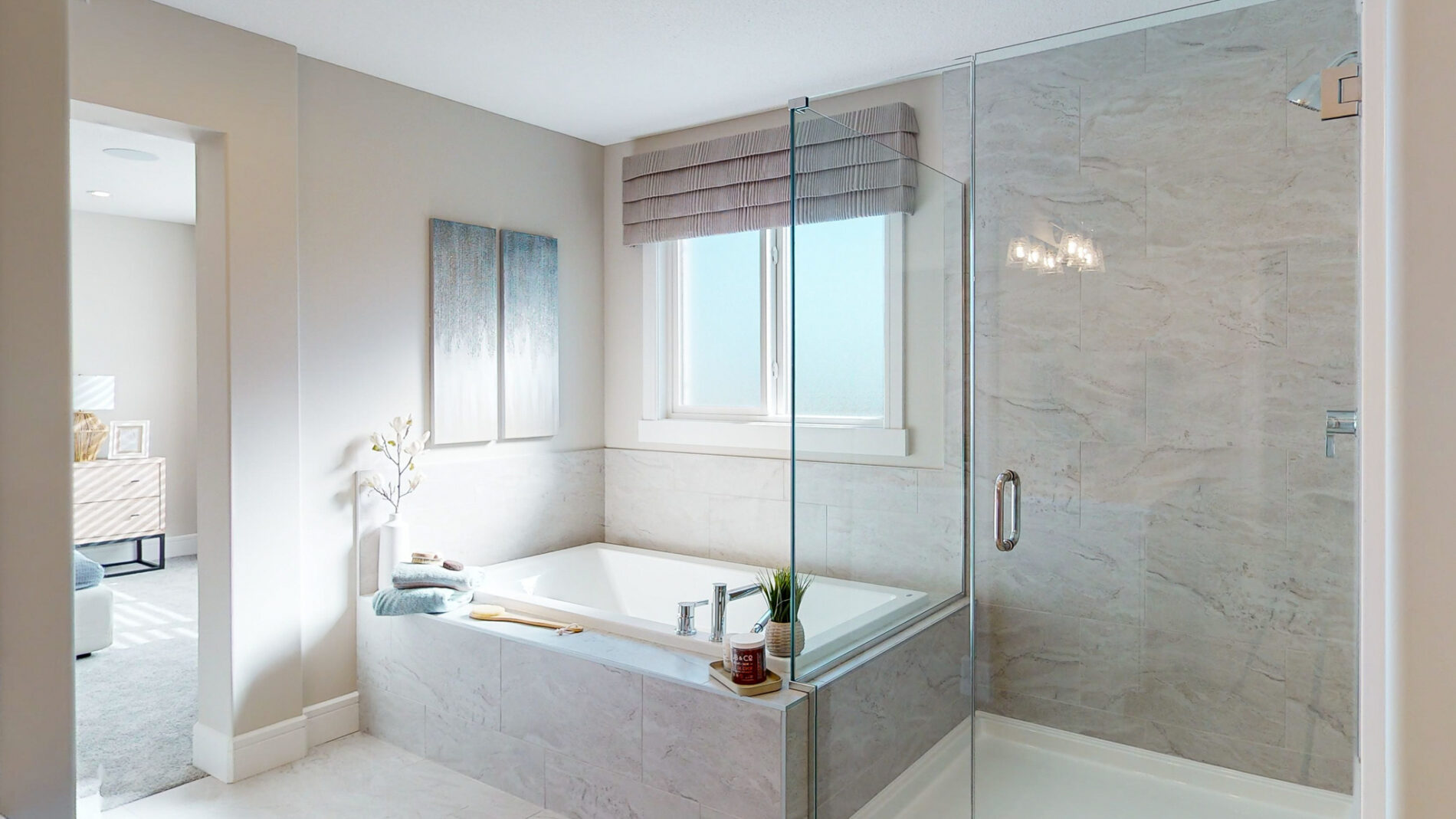 Natural light floods in through the window above the soaker tub next to the glass enclosed, fully tiles shower of the Kalliope Showhome