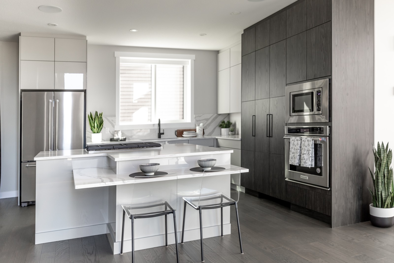 The sleek and modern two-toned, grey acrylic and dark sleek wood kitchen of the Cyrus showhome