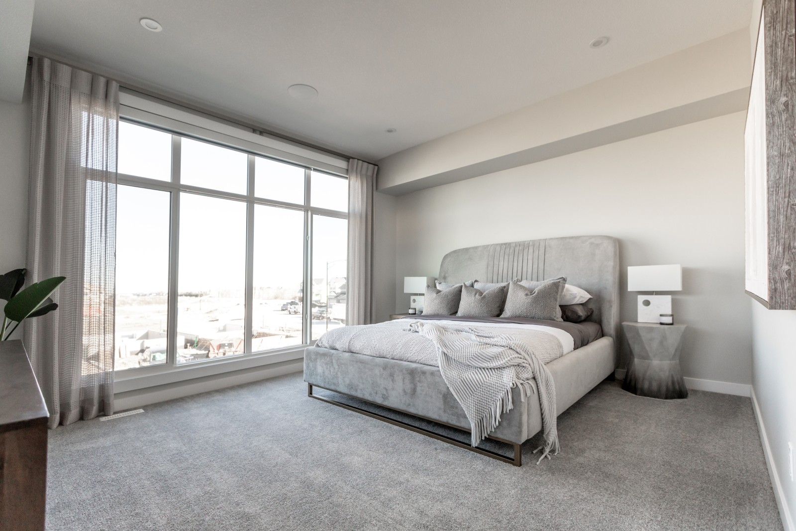 Natural light floods the master bedroom of the Cyrus showhome through an expansive window at the front of the room