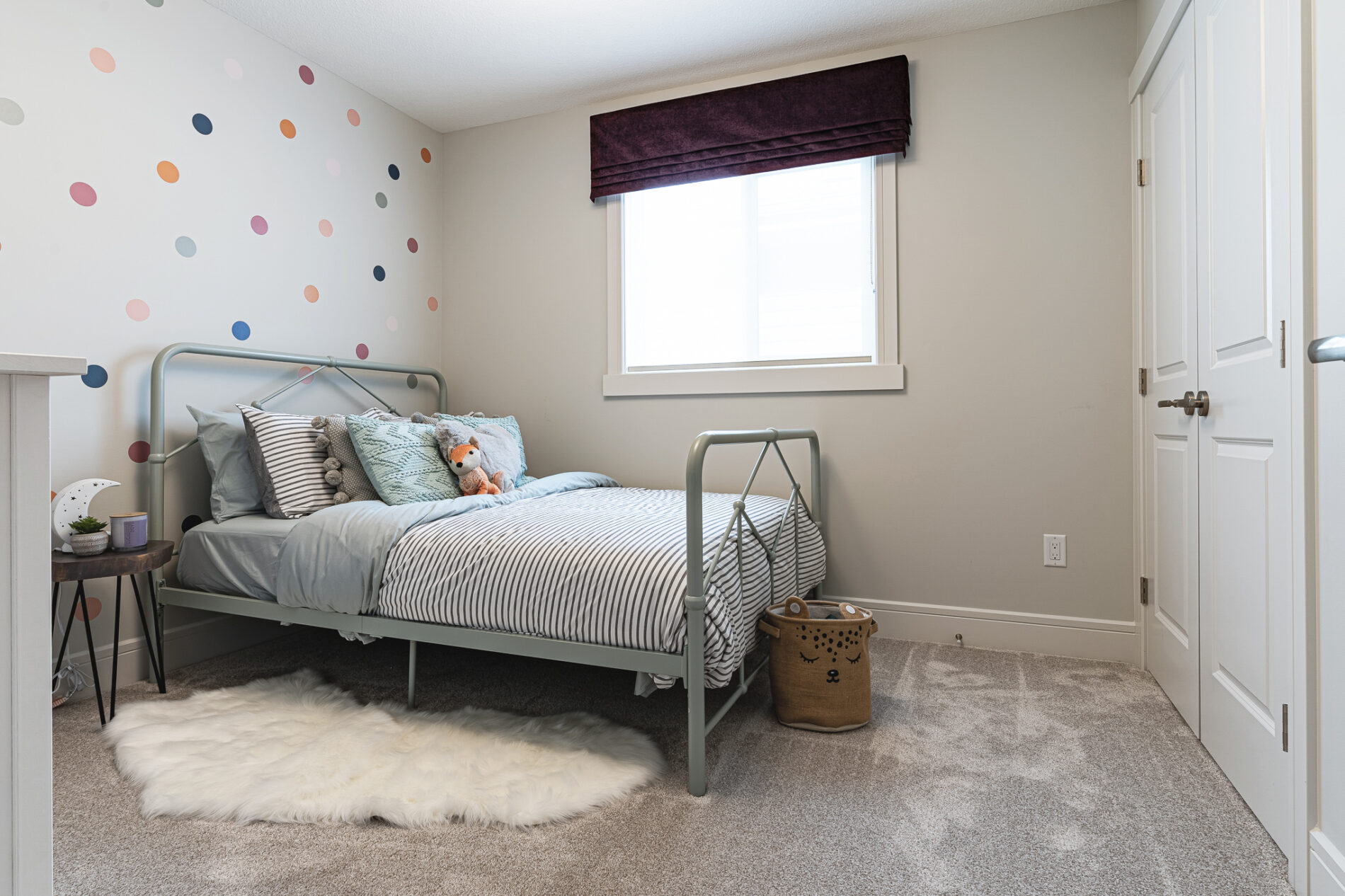 A polka dot wall behind the bed of a secondary bedroom in the Cassius showhome