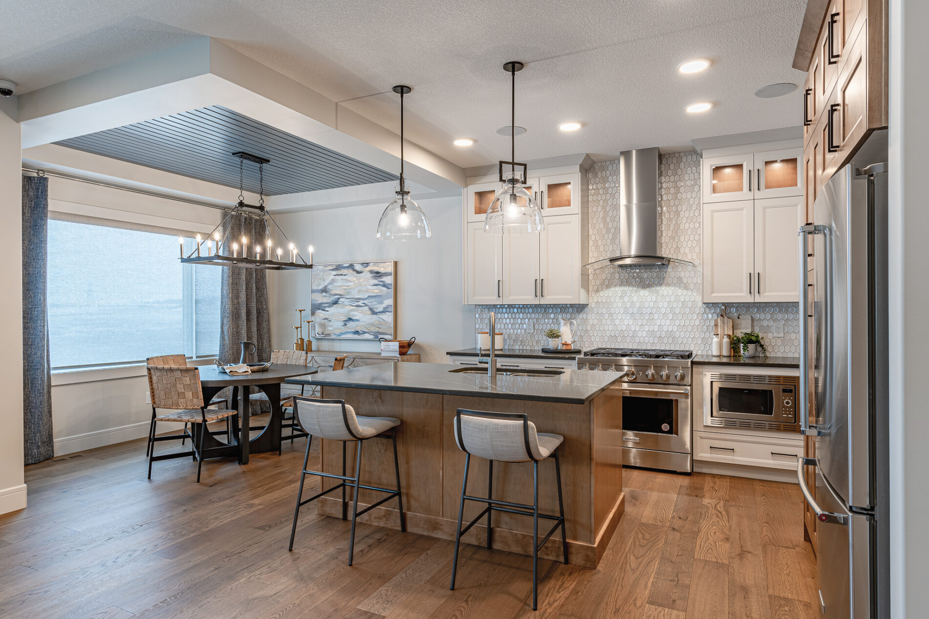 A two-toned white and wood kitchen with attached eating nook featuring a trayed ceiling detail with blue slats