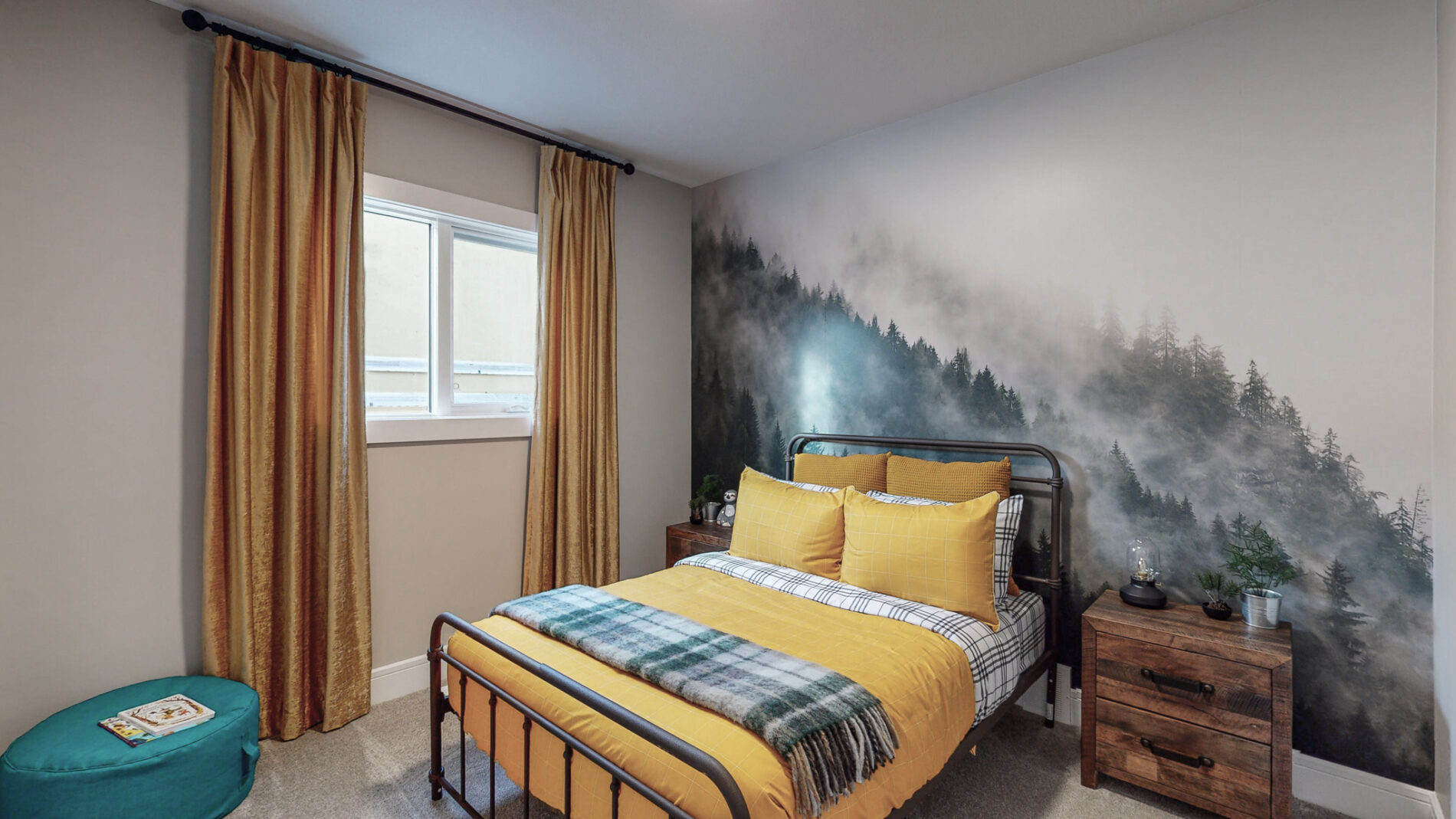 A natural mountain mural behind the bed of a secondary bedroom with yellow bedding and curtains