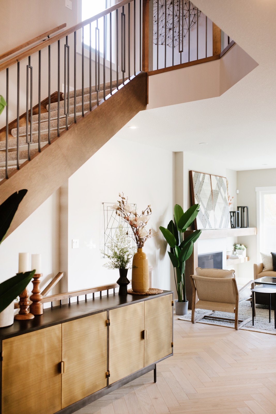 Custom open riser stairs with stained wood stringers and handrail leading to up to the second floor of the Cyrus showhome