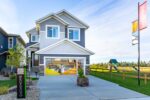 Photo of the exterior of a showhome featuring a glass store front where the garage door would be and playset to the right of the house.