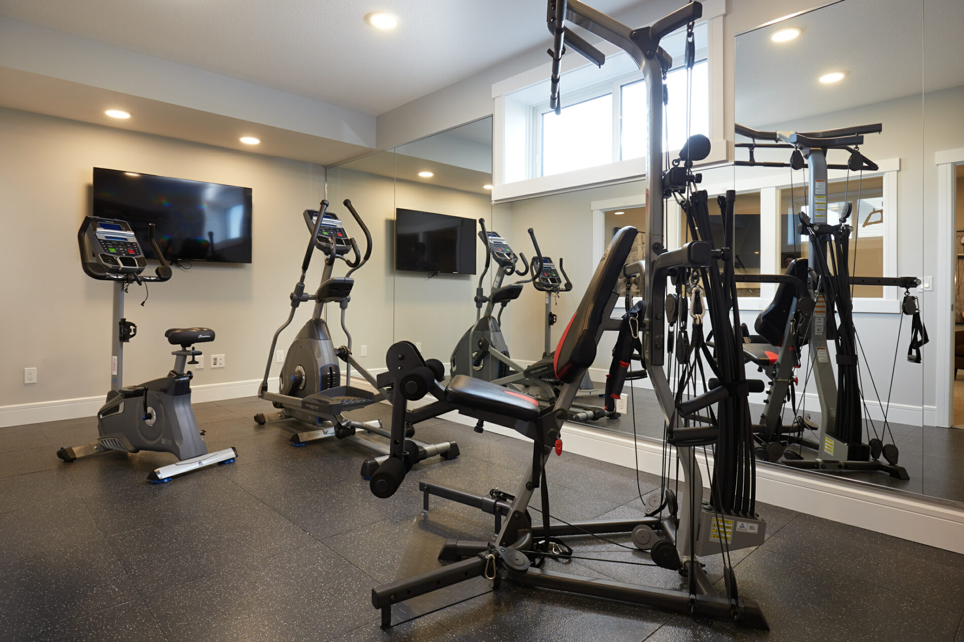 Basement in-home gym with black rubber flooring