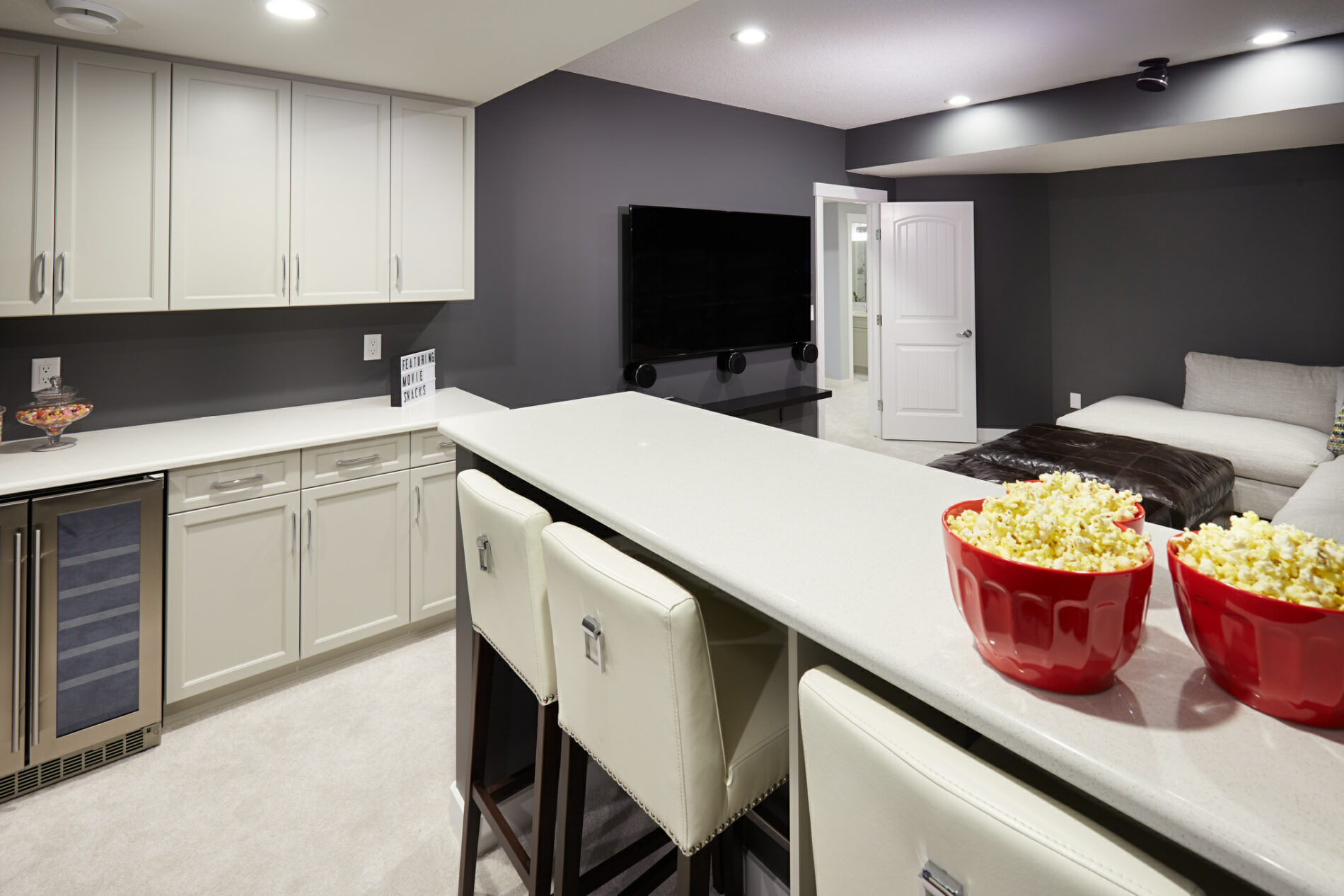 Theatre room in basement with eating bar and cabinets