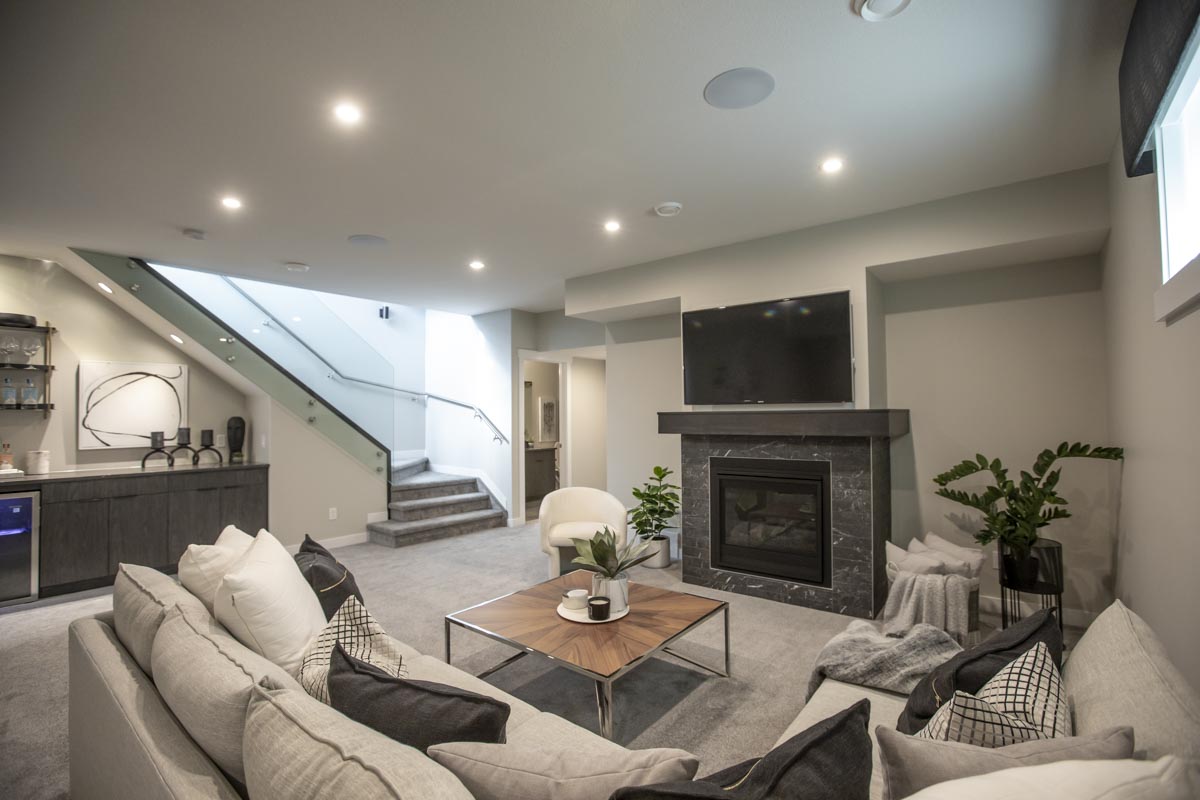 Family Room in basement of home with fireplace, couches, and a dry bar