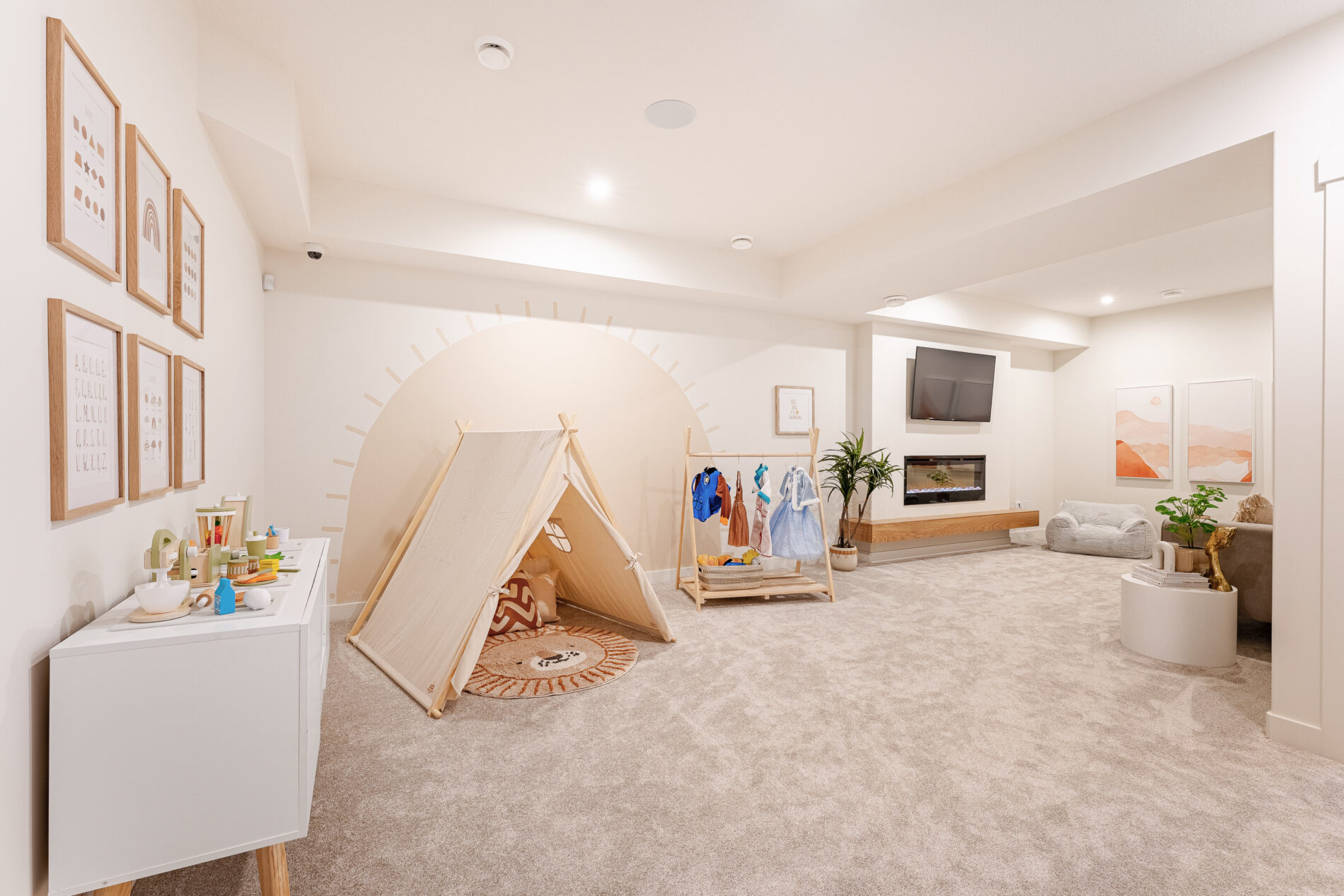 Imagination and play corner for kids in the basement of a house with costumes on a hanging rack and a small canvas play tent